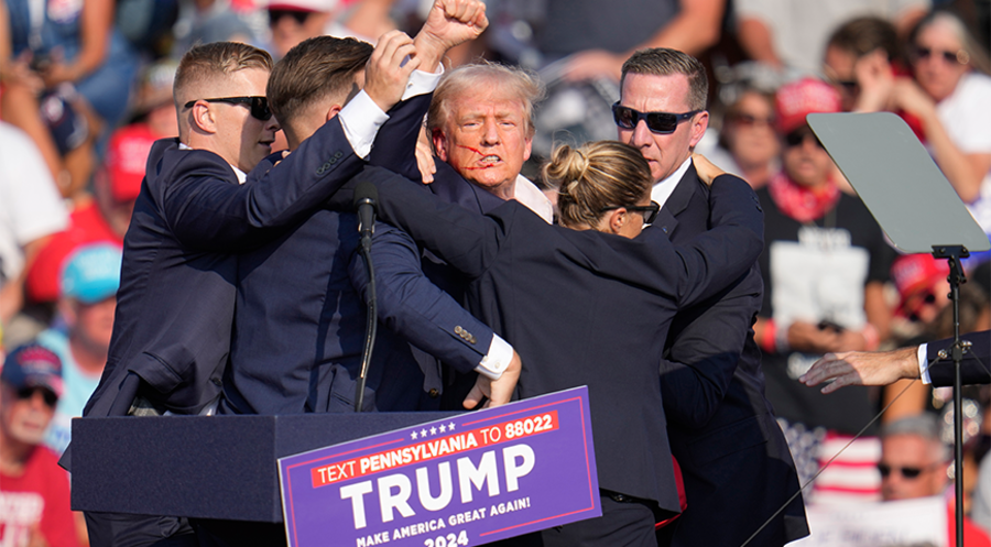 Donald Trump nach dem Schuss-Attentat, umringt von Sicherheitsbeamten. Foto: picture alliance/ASSOCIATED PRESS/Gene J. Puskar