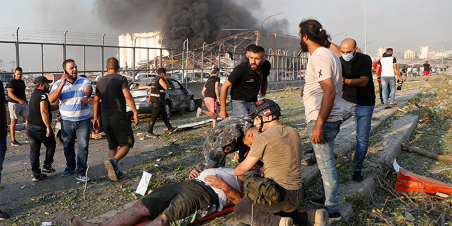 Rettungskräfte versorgen einen von der Explosion Verletzten. Foto: picture-alliance / ASSOCIATED PRESS / Hussein Malla