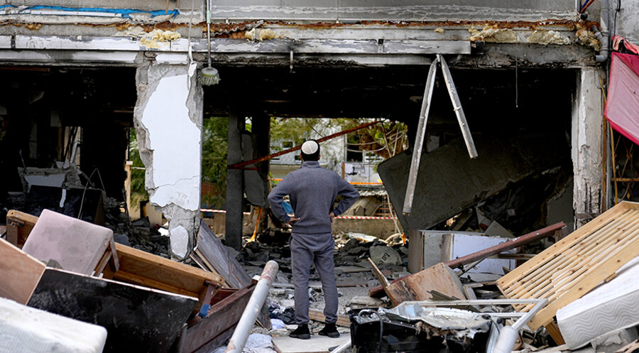 Ein Mann steht vor einem Haus im südisraelischen Ashkelon, das von Hamas-Raketen aus dem Gazastreifen zerstört wurde. Foto: picture-alliance/ASSOCIATED PRESS|Ohad Zwigenberg