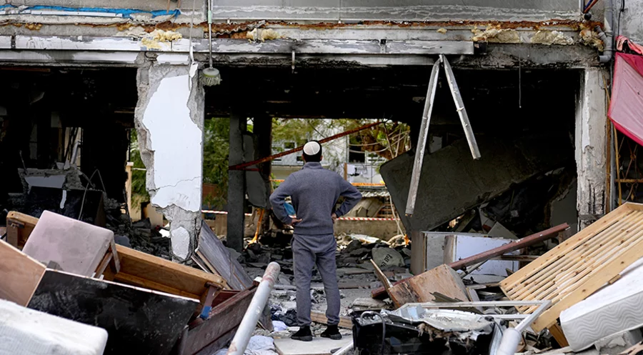 Ein Mann steht vor einem Haus im südisraelischen Ashkelon, das von Hamas-Raketen aus dem Gazastreifen zerstört wurde. Foto: picture-alliance/ASSOCIATED PRESS|Ohad Zwigenberg