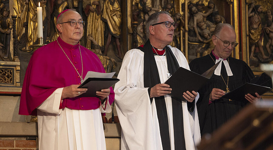 Christopher Easthill (Mitte) bei einem ökumenischen Gottesdienst am 1. Mai 2025 in der Marktkirche in Hannver mit dem Osnabrücker Bischof Dominicus Meier (links) und dem Landesbischof Ralf Meister (rechts). Foto: picture alliance / epd-bild | Paul-Philipp Braun