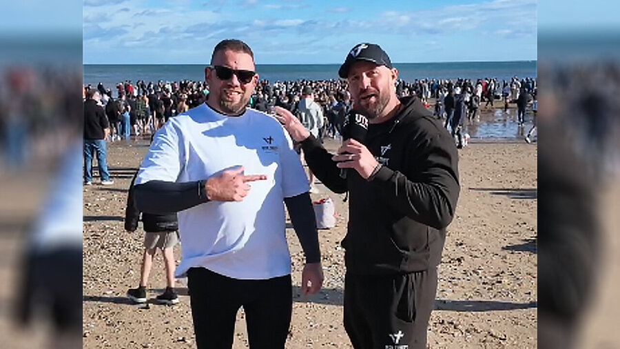 Der britische Influencer Merlin Kraft (li.) vor den zahlreichen Täuflingen. 