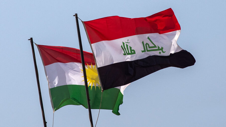 Flaggen des Irak und der Autonomen Region Irakisch-Kurdistan auf einem Hintergrund von blauem Himmel.