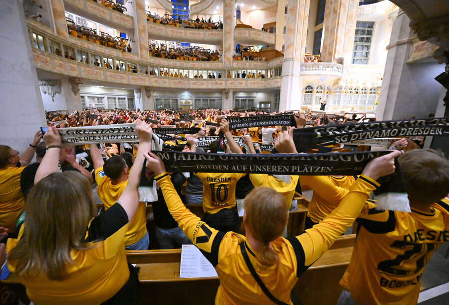 Ungewöhnliche Szenen in der Dresdner Frauenkirche: Dynamo-Anhänger halten ihren Fanschal hoch. 