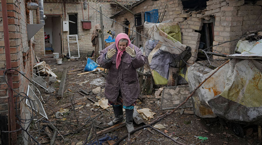 Eine Frau im verwüsteten Hinterhof ihres Hauses in der ukrainischen Hauptstadt Kiew. Foto: picture alliance / ASSOCIATED PRESS | Vadim Ghirda