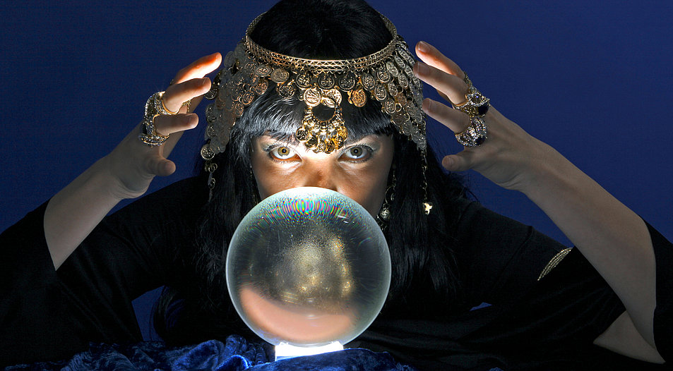 Eine Wahrsagerin vor ihrer Glaskugel, aus der sie die Zukunft vorhersagen will. Foto: Picture Alliance/McPhoto-PWI 