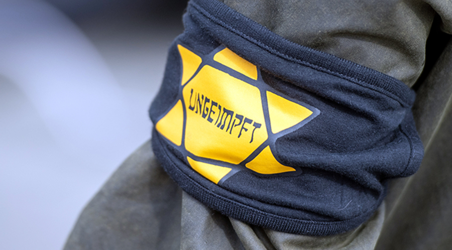 Ein Teilnehmer bei einer Demonstration mit einer Armbinde. Foto: Picture Alliance/Christophe Gateau