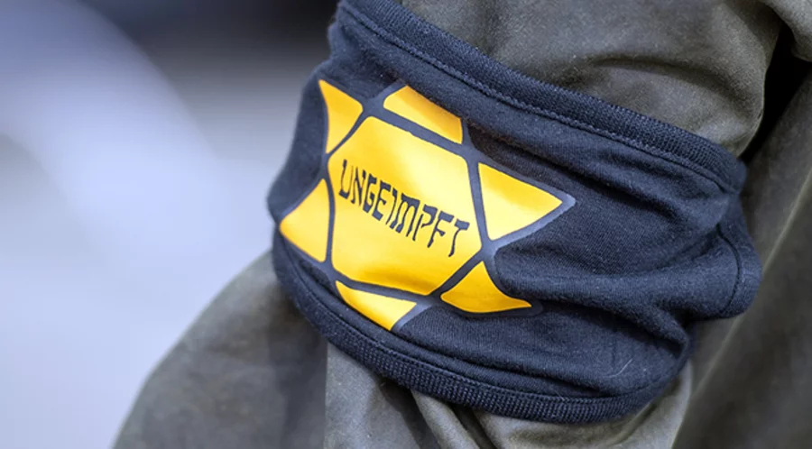 Ein Teilnehmer bei einer Demonstration mit einer Armbinde. Foto: Picture Alliance/Christophe Gateau