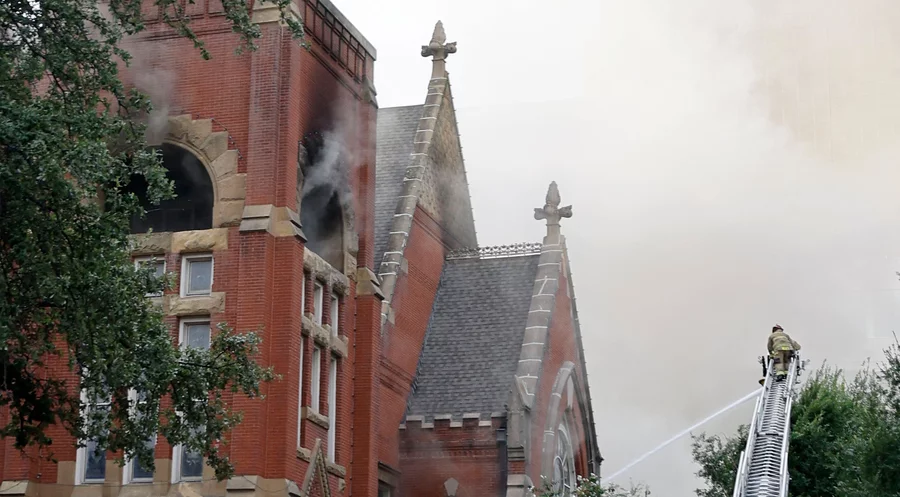 Ein Feuerwehrmann kämpft gegen das Feuer der „First Baptist Church“ in Dallas. Foto: picture alliance / ASSOCIATED PRESS | Chitose Suzuki