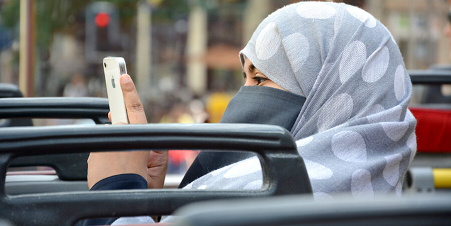 Eine Muslima mit Kopftuch nutzt ihr Smartphone in einem Bus. Foto: pixabay.com