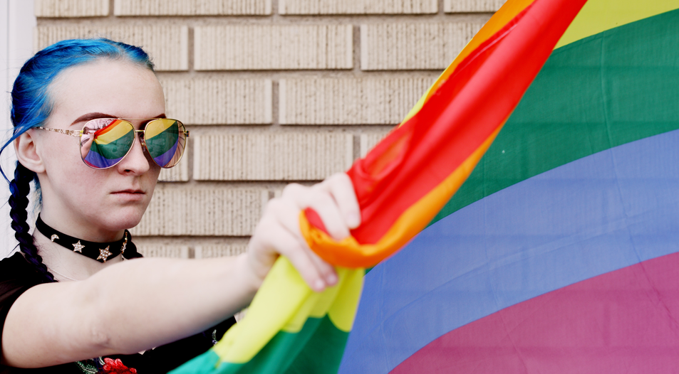 Ein Teenager mit einer Regenbogen-Flagge. Symbolfoto: unsplash.com