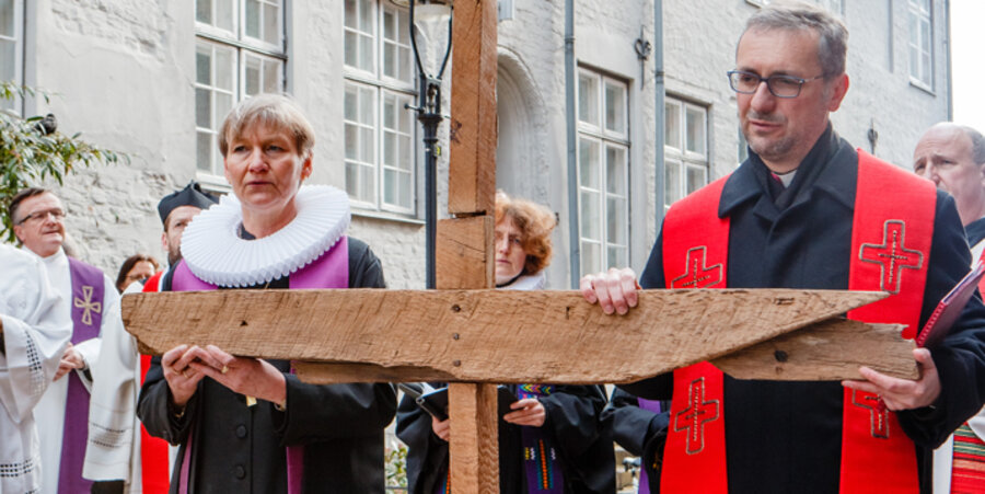 Kirsten Fehrs, Bischöfin der Evangelischen Nordkirche, und Stefan Heße, Erzbischof von Hamburg, halten in Lübeck, während eines ökumenischen Kreuzwegs am Karfreitag gemeinsam ein Kreuz. Foto: picture-alliance/dpa