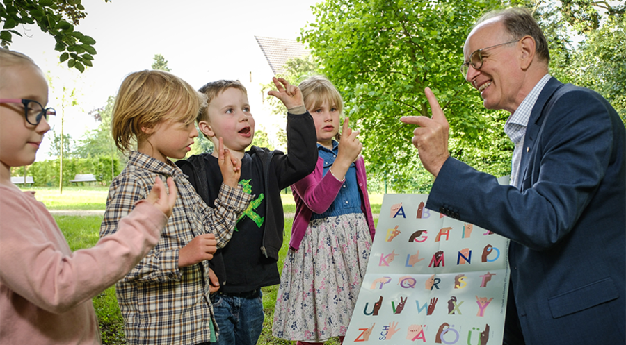 „Buchstaben mit Handbewegungen zu verknüpfen, macht das Lernen leichter“: Der hannoversche Landesbischof Ralf Meister mit Erstklässlern. Foto: Jens Schulze