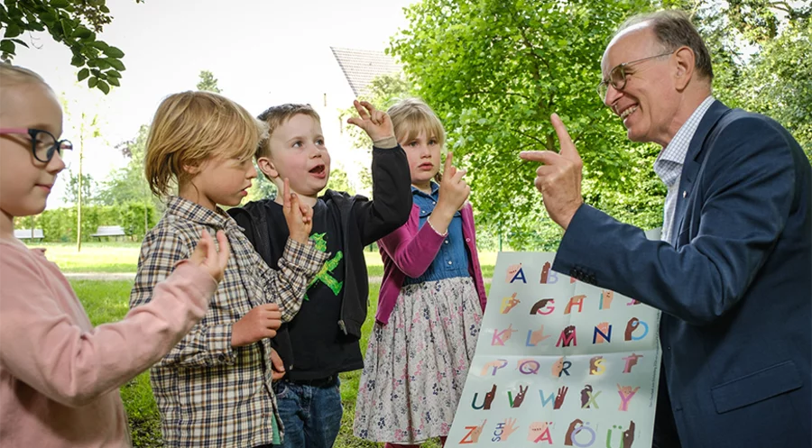 „Buchstaben mit Handbewegungen zu verknüpfen, macht das Lernen leichter“: Der hannoversche Landesbischof Ralf Meister mit Erstklässlern. Foto: Jens Schulze