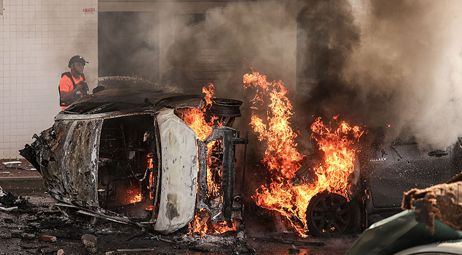 Eine Rakete aus Gaza hat einige Autos getroffen und in Brand gesteckt. Foto: picture-alliance/dpa|Ilia Yefimovich