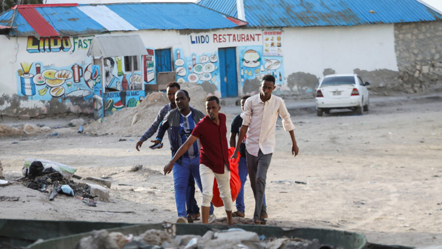 Helfer bergen ein Opfer des Anschlags am Strand von Mogadischu. Foto: picture alliance / REUTERS | Feisal Omar