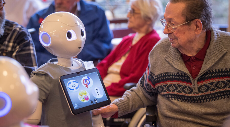 Auf Tuchfühlung mit Roboter „Pepper“ geht ein Bewohner eines Alten- und Pflegeheims in Hessen. Foto: picture alliance/dpa | Boris Roessler