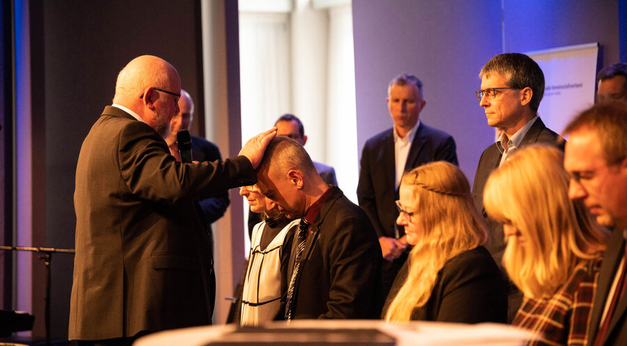 Hartmut Schmid segnet den neuen Vorstand mit den Ehepartnern. Foto: C. Käfferlein