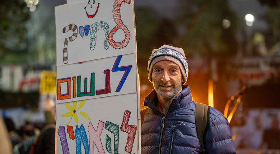 „Lächeln, Atmen, Glauben“ steht auf dem Schild eines Demonstranten. Foto: IDEA/Valentin Schmid