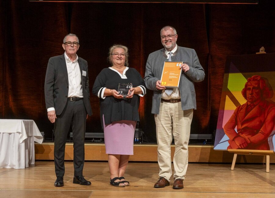 Claus Ebeling (l) und Ulla Mörtel-Then (m) vom Verein "MundArt in der Kirche" nahmen den Initiativpreis von Prof. Andreas Gardt (r) entgegen.