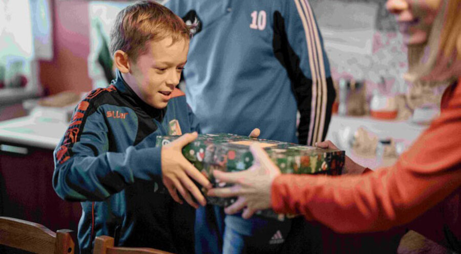 Ein Junge erhält sein Schuhkartongeschenk bei einer Haus-zu-Haus-Verteilung 2021 in Polen. Foto: Zimpfer_Photography