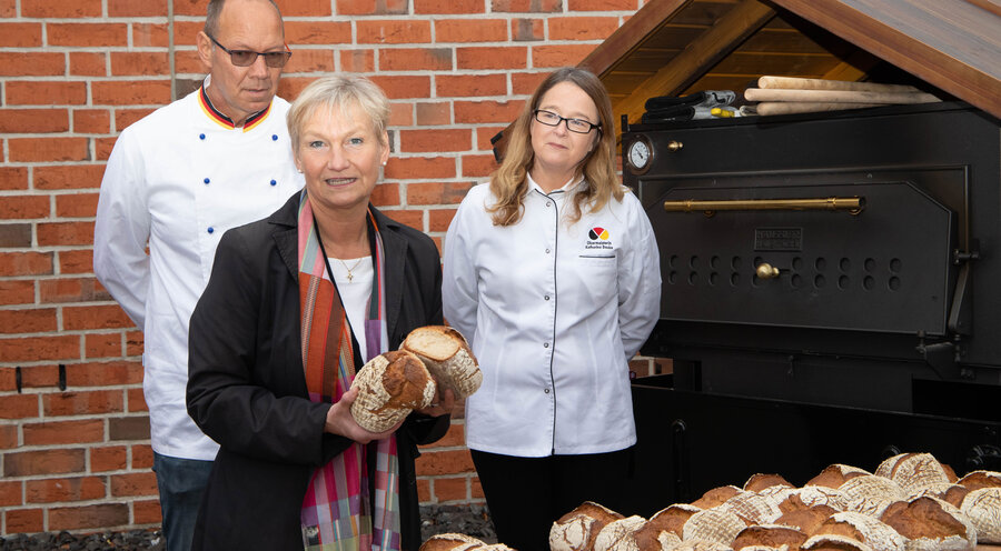 Die Bischöfin im Sprengel Hamburg und Lübeck der Nordkirche, Kirsten Fehrs (im schwarzen Blazer), mit zwei Bäckern. Foto: Bäckerinnung Hamburg 