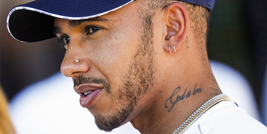 Der viermalige Formel 1-Weltmeister Lewis Hamilton bezeugt seinen Glauben mit einem Tattoo am Hals: “God is love” (Gott ist Liebe). Foto: picture-alliance/DPPI Media