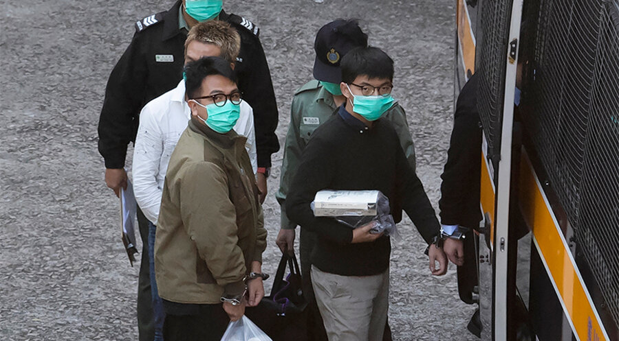 Joshua Wong (rechts) und Ivan Lam (links) werden von Sicherheitsbeamten zum Prozess gebracht. Foto: picture alliance / ASSOCIATED PRESS | Kin Cheung