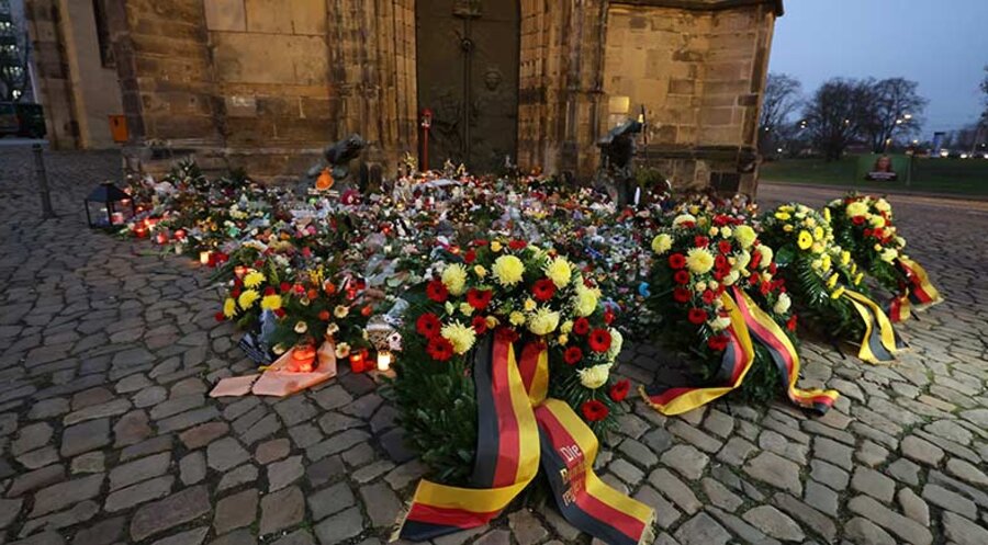 Vor dem Portal der Johnanniskirche erinnern Blumen und Kränze an die Opfer des Anschlags auf dem Weihnachtsmarkt in Magedeburg. Foto: picture-alliance/dpa|Jan Woitas