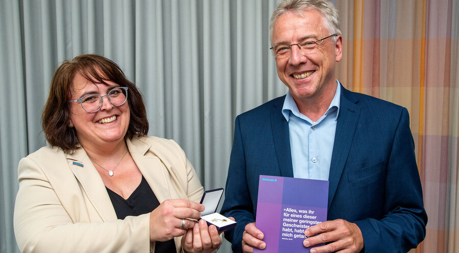 Dr. Angela Rascher, Pfarrerin und Theologische Referentin der Diakonie Hessen, verleiht das Goldene Kronenkreuz an Johannes Bormuth. Foto: Deutscher Gemeinschafts-Diakonieverband e.V.