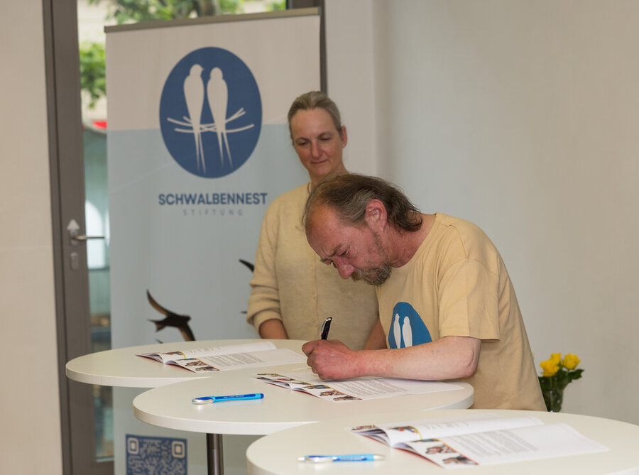 „Schwalbe“ beim Unterzeichnen der Gründungsurkunde der „Schwalbenneststiftung“.
