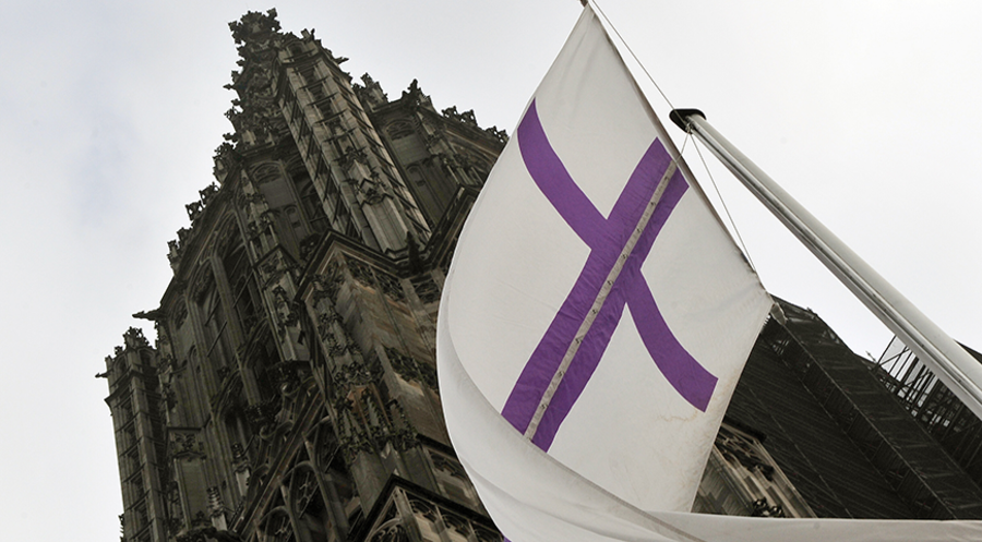 Eine Fahne der Evangelischen Kirche in Deutschland am Ulmer Münster. Foto: picture-alliance/ dpa/Stefan Puchner