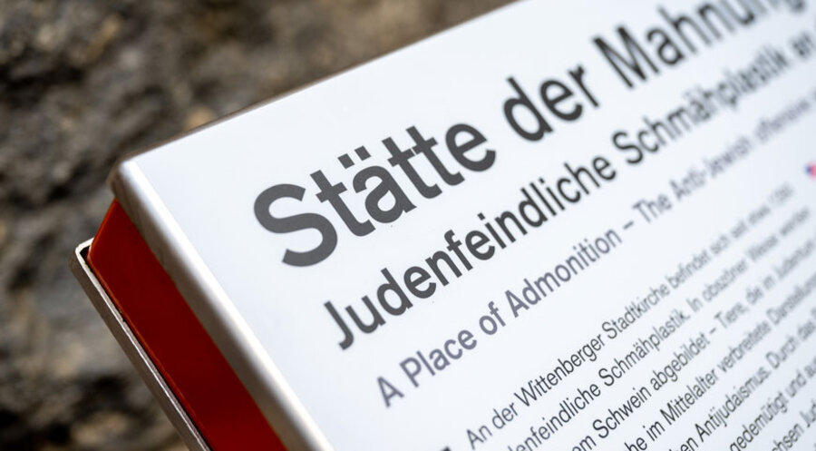 Ein neuer Text ist auf einer Infotafel unterhalb der als „Judensau“ bezeichneten Schmähplastik an der Stadtkirche Wittenberg zu sehen. Foto: Picture Alliance/Hendrik Schmidt