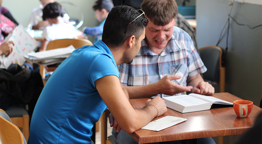 Treffpunkt Xenos-Café: Ein Mitarbeiter im Gespräch mit einem Migranten. Foto: OM/Anita Evans