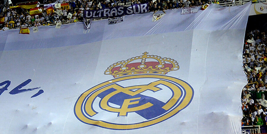 Fans von Real Madrid rollen im Bernabeu-Stadion ein Plakat mit dem Wappen des Vereins zur Unterstützung ihrer Mannschaft aus. Foto: picture-alliance/Pressefoto ULMER/Markus Ulmer