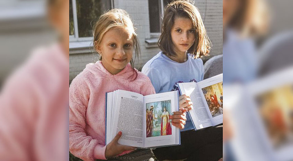 Die Mädchen Darja (8 Jahre, links) und Polina (10) mit einer Kinderbibel von der Ukrainischen Bibelgesellschaft. Foto: Kristina Gogiya