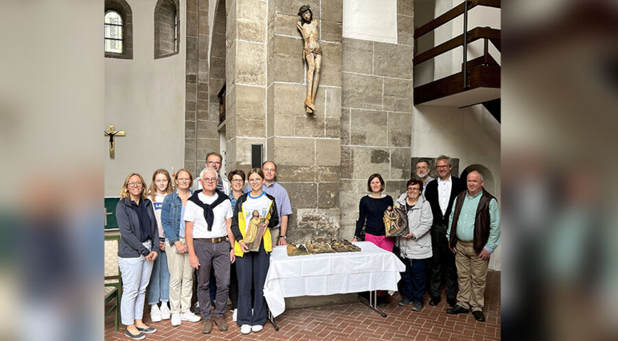Gemeindeglieder, Mitglieder des Gemeindekirchenrates, der Pfarrer Klemens Müller sowie Gäste vor dem wieder aufgehängten Kruzifix. Foto: Steffen Mund