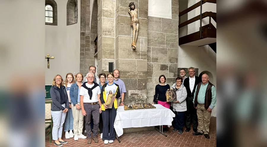 Gemeindeglieder, Mitglieder des Gemeindekirchenrates, der Pfarrer Klemens Müller sowie Gäste vor dem wieder aufgehängten Kruzifix. Foto: Steffen Mund