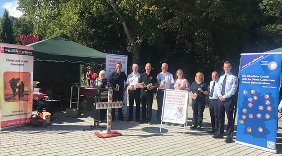 Der gemeinsame Informationstand der CFV und CPV auf der Landesgartenschau. Mitarbeiter stehen vor dem „Feuerwehr-Bibelkreuz“. Foto: CFV Bernd Kramp