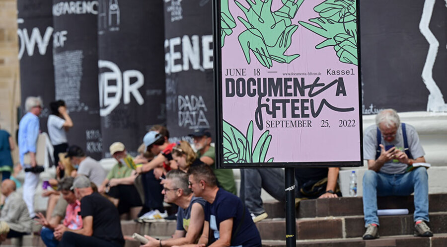 Besucher der documenta fifteen sitzen auf den Stufen des Fridericianums. Foto: picture alliance/dpa | Uwe Zucchi