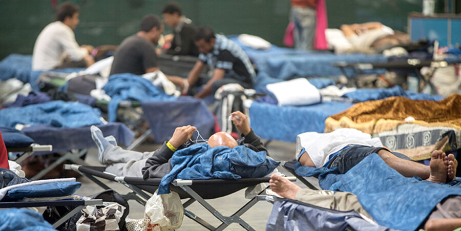 Flüchtlinge in einer Notunterkunft warten auf ihre Aufenthaltsgenemigungen. Foto: picture-alliance/dpa